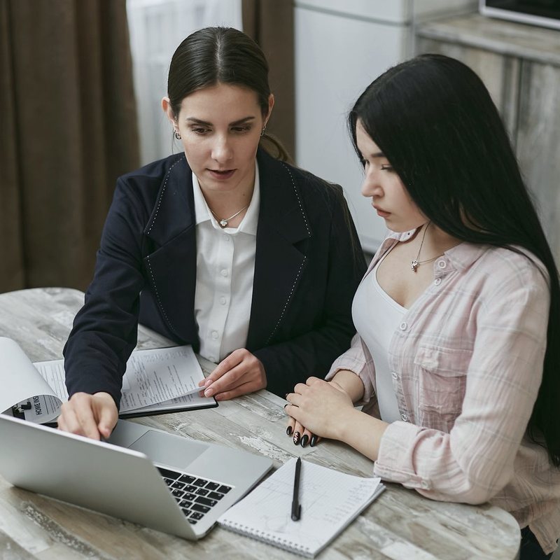 Two women looking at a laptop together at a table
