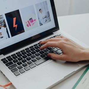 Person typing on a laptop with a website on the screen