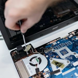 Technician using a screwdriver inside an open laptop
